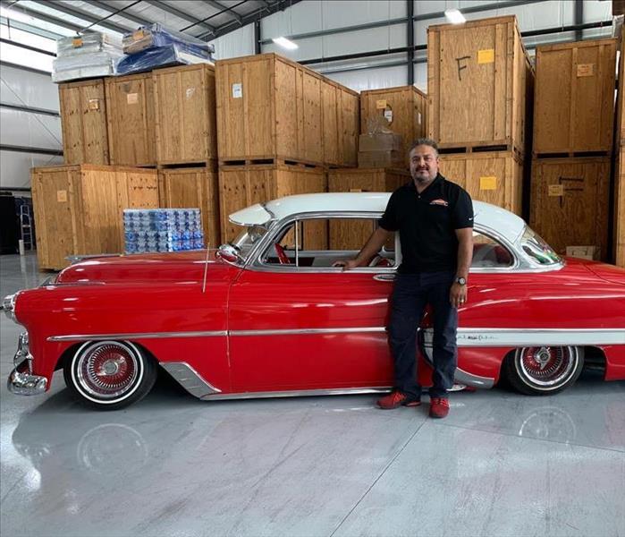 a guy in front of a red car